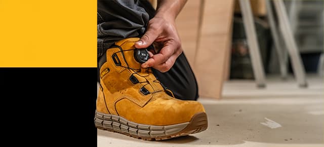A DeWalt Lancaster honey boot on a work site with BOA technology - a hand turns the dial