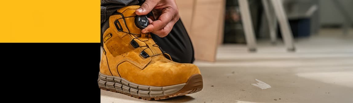 A DeWalt Lancaster honey boot on a work site with BOA technology - a hand turns the dial
